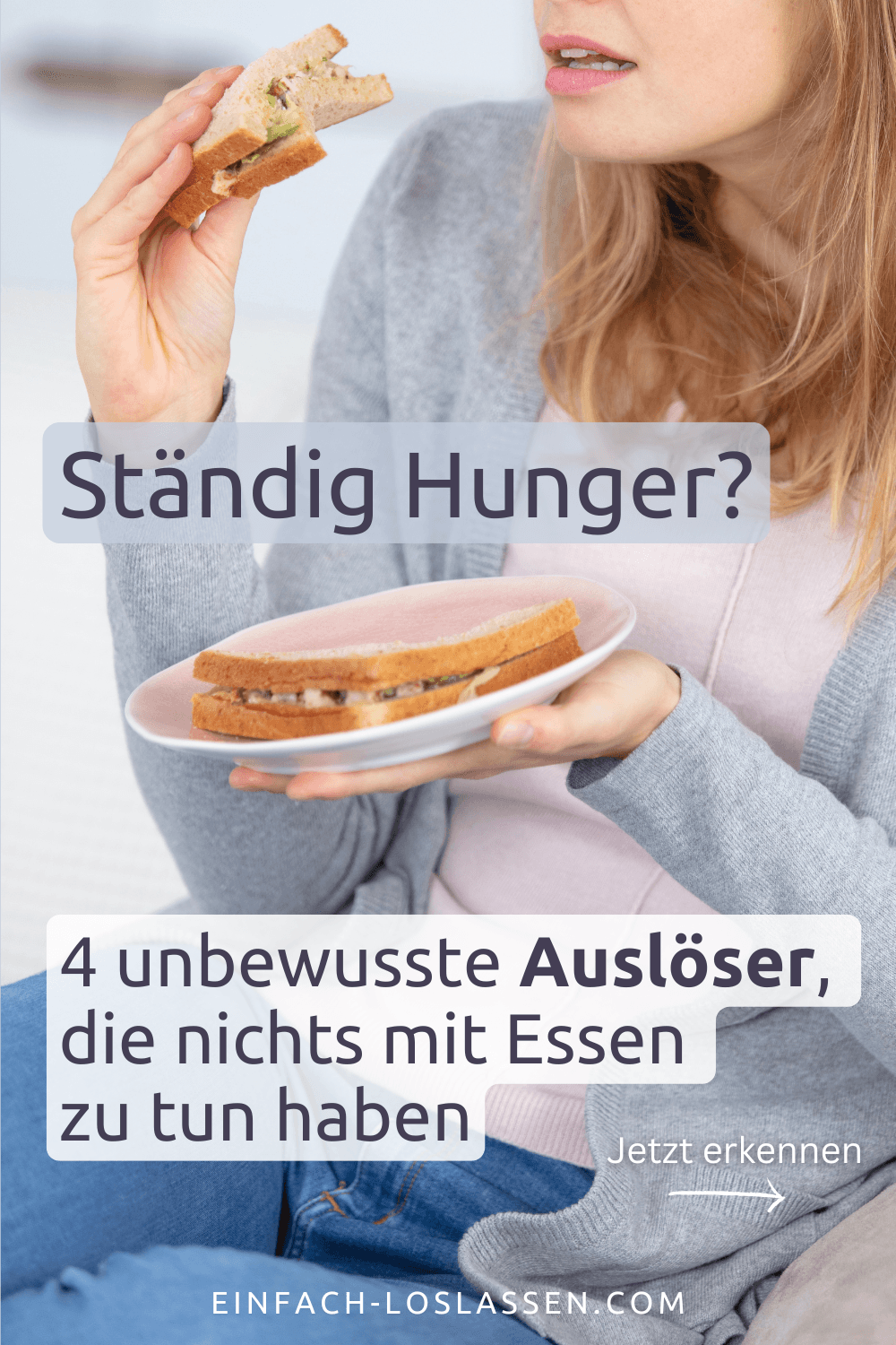 Ständig Hunger Eine Frau mit blonden Haaren in einer grauen Strickjacke isst ein Sandwich auf der Couch. Sie hat abends ständig Hunger.