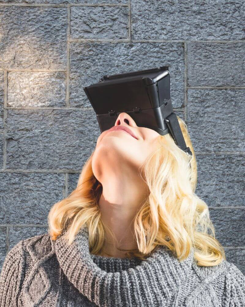 3 blinde Flecken, die dein Essverhalten bestimmen. Eine blonde Frau in einem grauen Pulli schaut durch eine VR-Brille nach oben - sie hat blinde Flecken in ihrem Essverhalten.